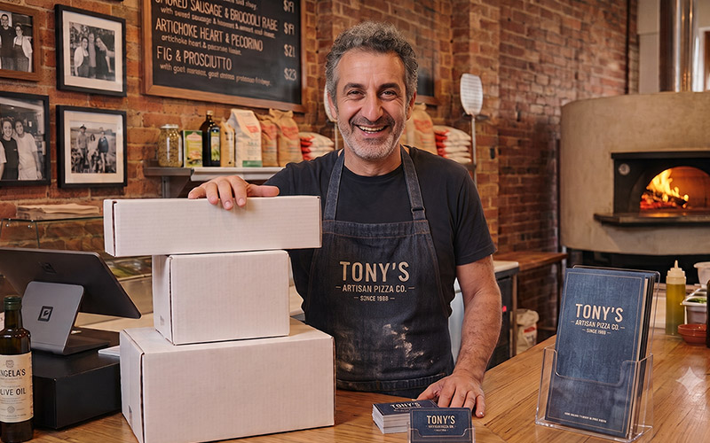 Tony's Artisan Pizza Co. after ZOOGABOOG!, in a branded apron with matching packaging and business cards